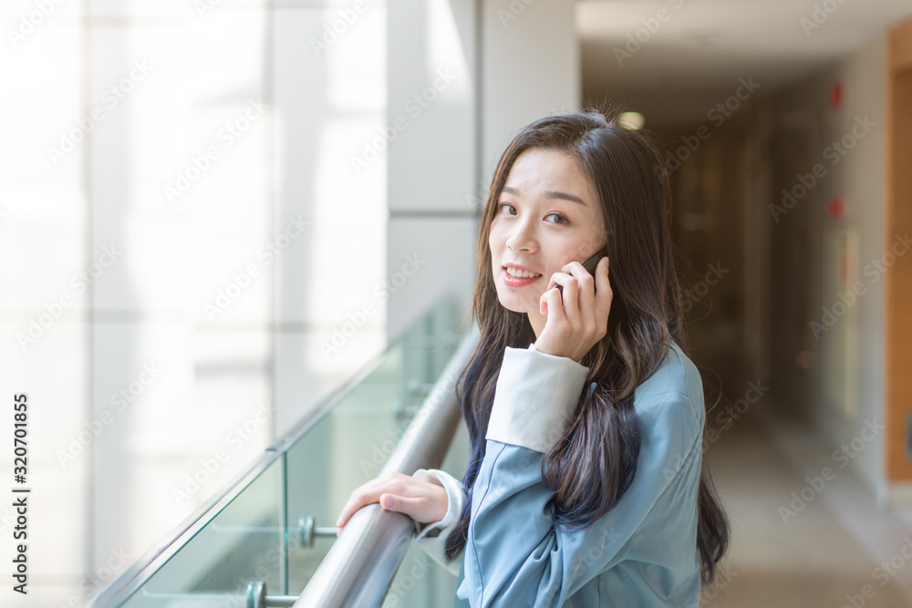 Young business lady calls in the corridor of the office building Young business lady calls in the corridor of the office building
