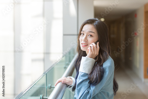 Young business lady calls in the corridor of the office building