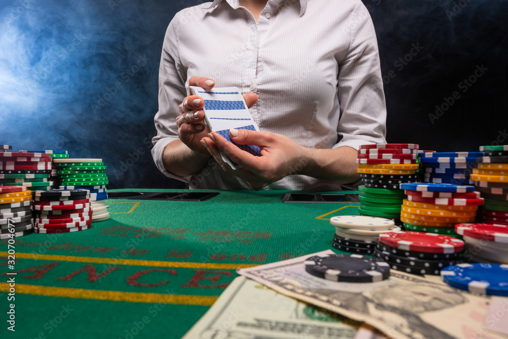 Girl dealer, in the casino gives out cards. A lot of chips, money. The concept of business, games and casinos. Girl dealer, in the casino gives out cards. A lot of chips, money. The concept of business, games and casinos.