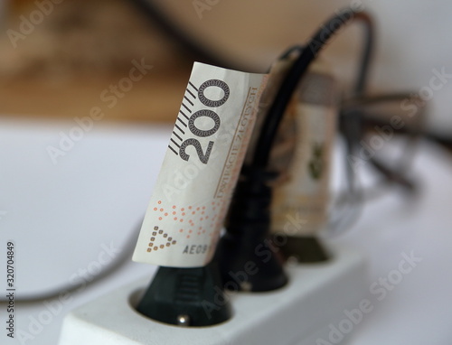 Bilde på lerret 200 Polish zloty banknote between wires of plugs in electric extension cord clos