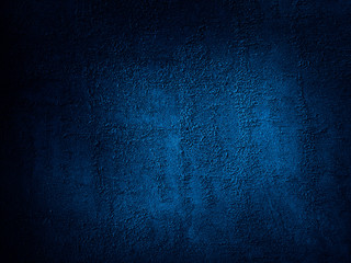 Dark blue grunge background. Rough grainy concrete wall surface texture. Close-up. Abstract blue background. Dark blue concrete background. Detail. Copy space for your design.