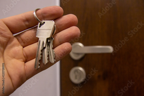 Holding a bunch of keys on the background of door