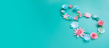 The number 8 is made of flowers cut from paper on a mint background