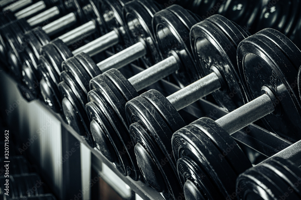 Sports equipment in gym. Dumbbells of different weight close up Sports equipment in gym. Dumbbells of different weight close up