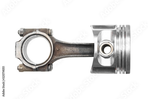 Old car engine piston with connecting rod isolated on white background.