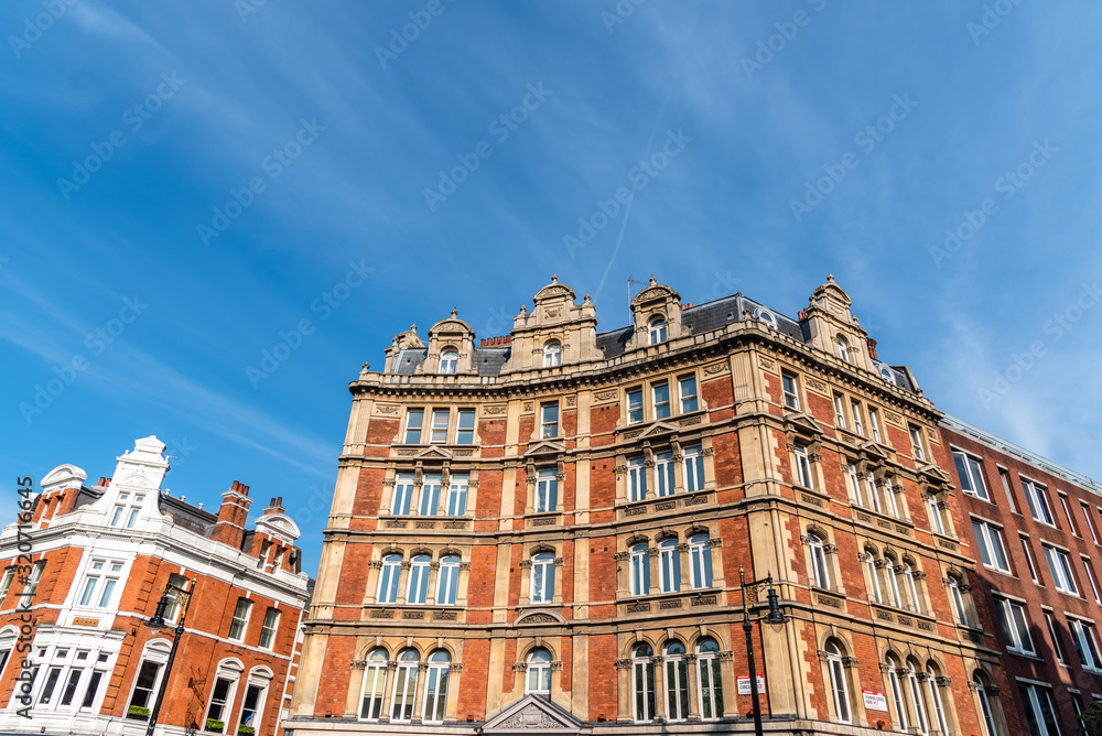 Old residential buildings in the city of London against blue sky
