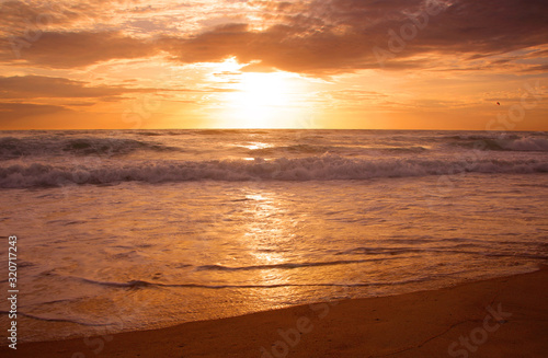 Beautiful sunset on tropical beach. The surf pounds the shore. Karon beach  Phuket  Thailand