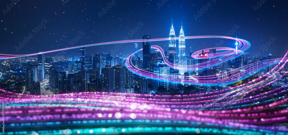 Naklejka premium Night city with abstract gradient blue and red glowing light trail surround the city ,Smart city big data connection technology concept .