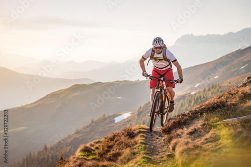 Foto Male mountainbiker riding on a trail in the mountains