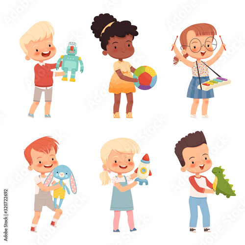 Happy children play with different toys, hold them in their hands. Funny kids of different nationalities with favorite toys.