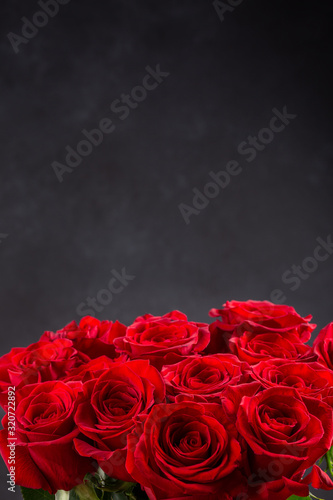Fototapeta Naklejka Na Ścianę i Meble -  Bouquet of red roses.  Beautiful flowers on a black background. Copy space.