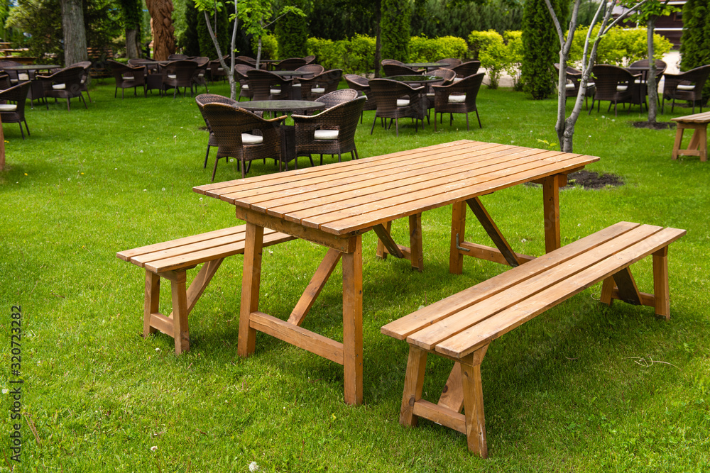 Long wooden natural bench and table outdoors