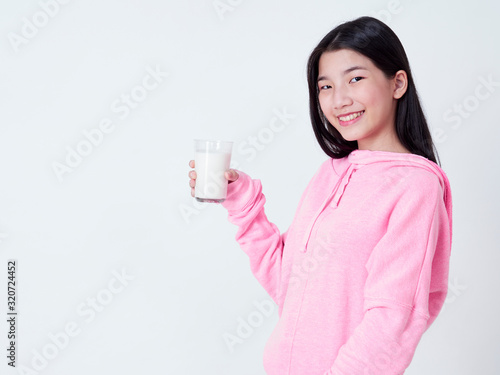 Teenage girls holding a glass of milk.