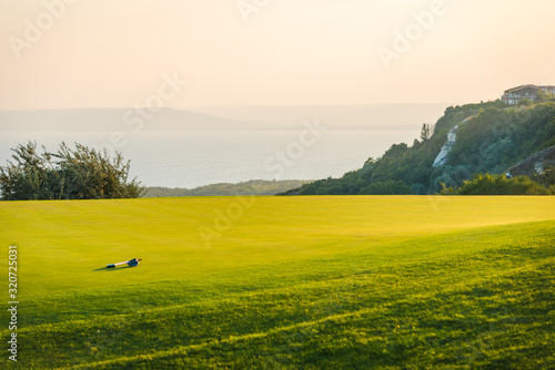 Принти на полотні Golf club lawn by th sea and a golf stick.
