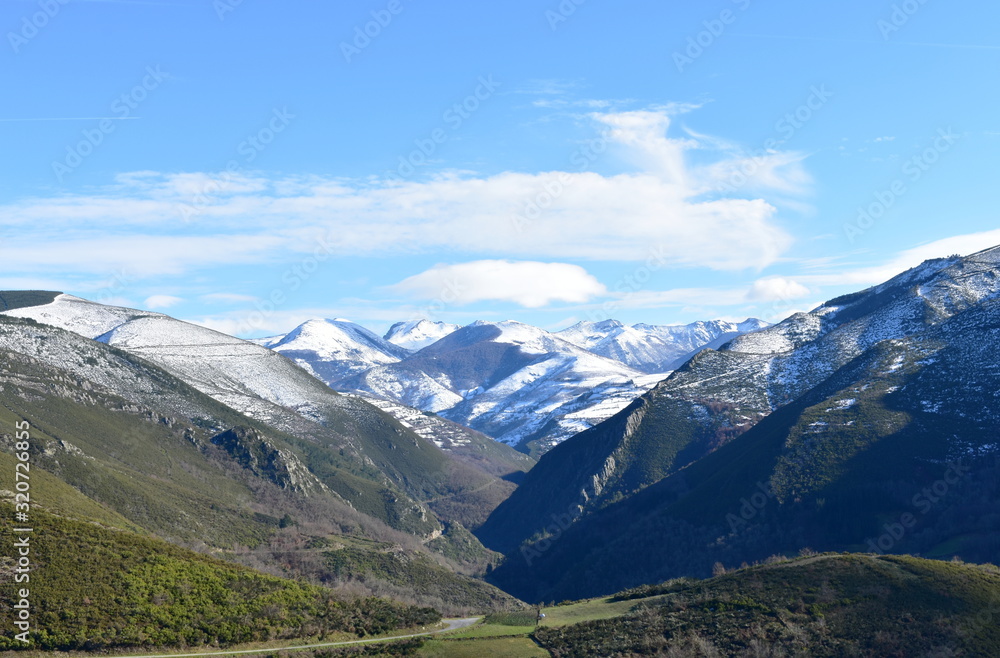 Winter landscape with snowy mountains and green valley with forest on a sunny day. Ancares, Lugo, Galicia, Spain. Winter landscape with snowy mountains and green valley with forest on a sunny day. Ancares, Lugo, Galicia, Spain.