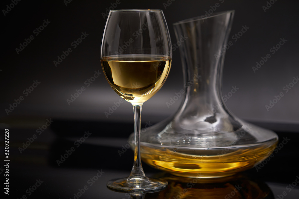 A glass full of wine and wine decanters A glass full of wine and wine decanters