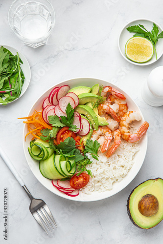 Avocado, prawn, cucumber, tomato, radish, carrot and rice salad bowl. Healthy food.