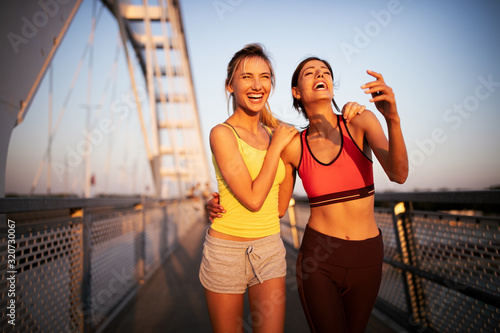 Fit happy friends jogging and running together outdoor in city