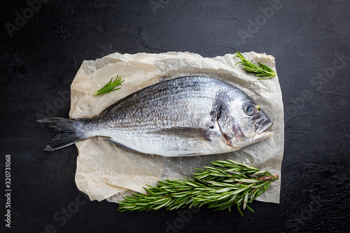 Foto Fresh ready to cook raw bream fish dorado with ingredients and seasonings like r