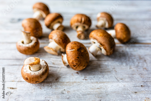 Fresh brown mushrooms in a wooden background.