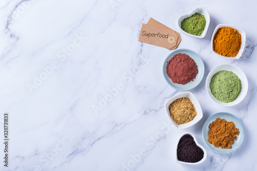 Assortment of superfood powder, acai, turmeric, ginger, matcha, cinnamon, wheat