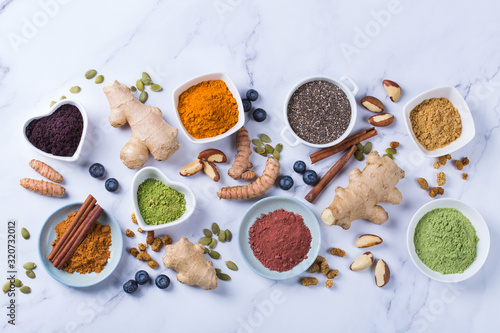 Assortment of superfood powder, acai, turmeric, ginger, matcha, cinnamon, wheat photo