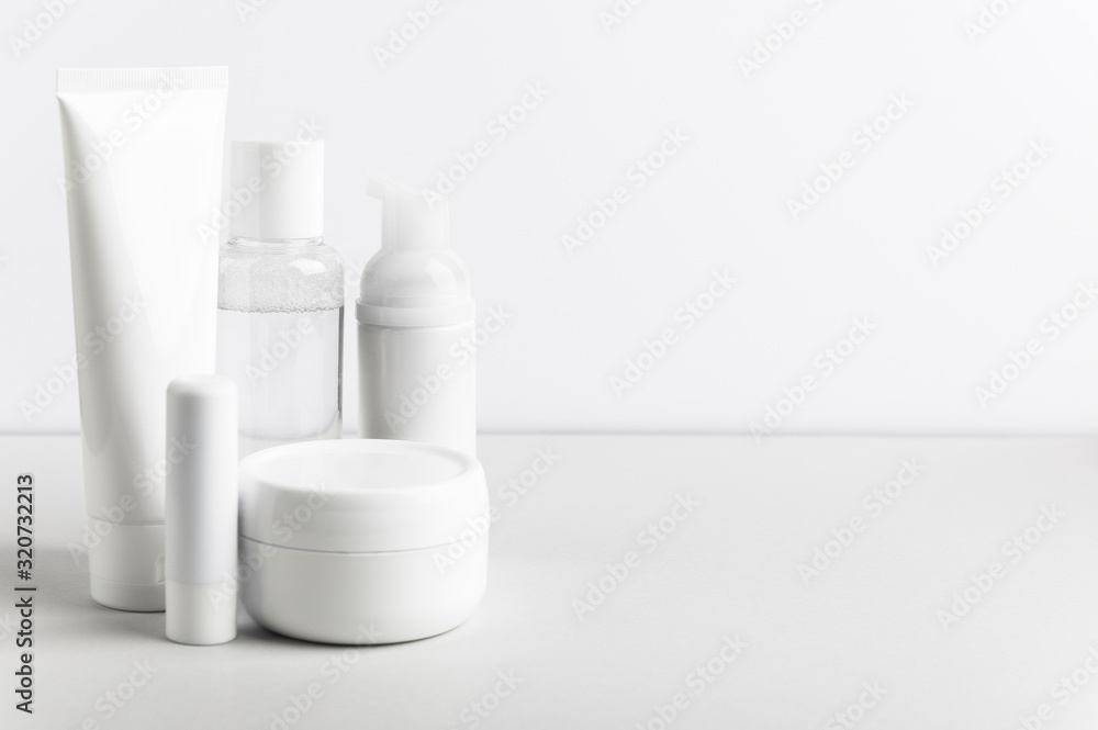 Facial and body care cosmetics bottles composition on white background. Gel tube, lipstick, cream jar unbranded blank packages. Skincare female products advertising with light backdrop