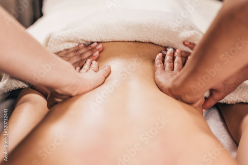 Four hands back massage - female hands on the patient s back