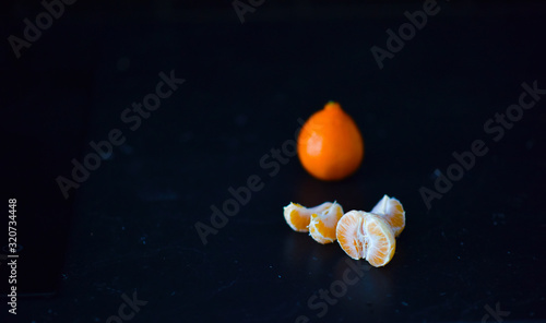 orange Mandarin slices on a black background