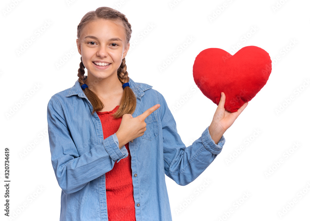 Valentines Day concept. Portrait of cute teen girl with red heart, isolated on white background. Smiling child holds symbol of love, family, hope. Cute caucasian teenager holding plush heart in hands. Valentines Day concept. Portrait of cute teen girl with red heart, isolated on white background. Smiling child holds symbol of love, family, hope. Cute caucasian teenager holding plush heart in hands.