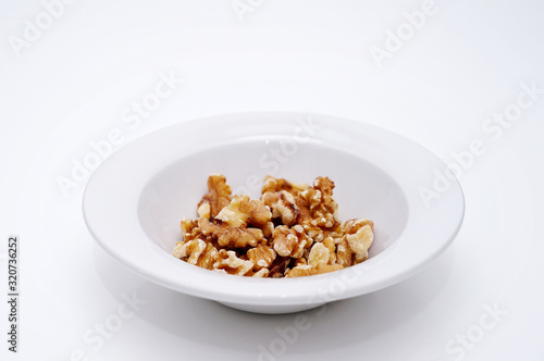 white bowl with peeled walnuts