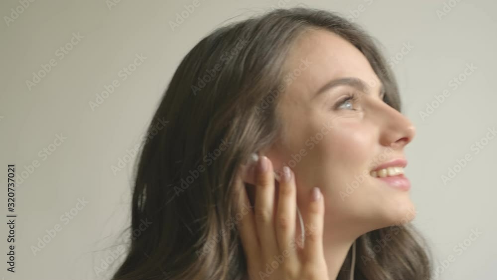 A good looking woman is enjoying the music using wired headphones indoors A good looking woman is enjoying the music using wired headphones indoors