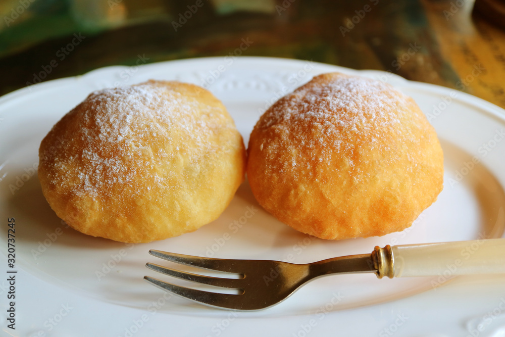 Pair of tasty fresh fried Georgian doughnuts sprinkled with icing sugar