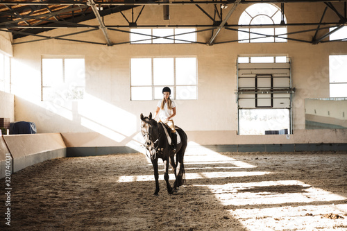 Obraz na plátně Beautiful woman wearing hat with horse