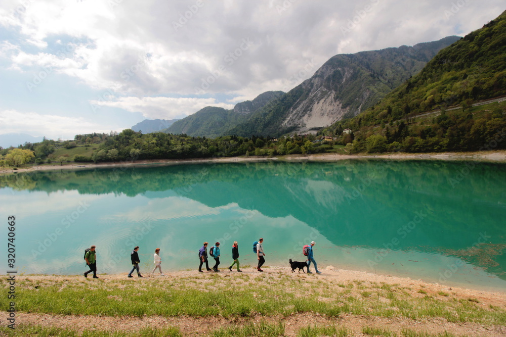 Gruppo di persone camminano sulla costa di un lago Gruppo di persone camminano sulla costa di un lago