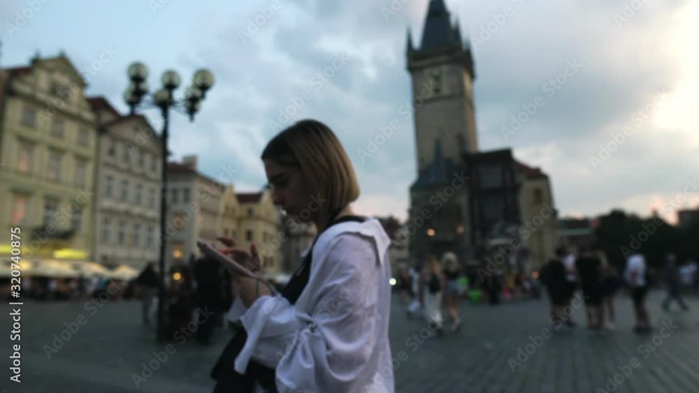 The girl works on the phone in the center of Prague The girl works on the phone in the center of Prague