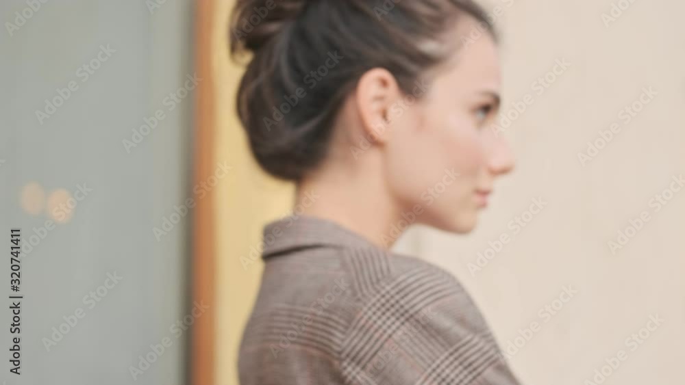 A calm stylish businesswoman is staying with crossed hands outside A calm stylish businesswoman is staying with crossed hands outside