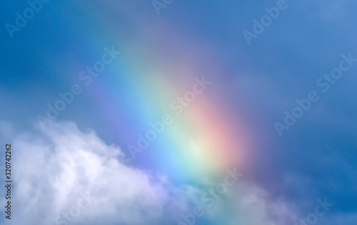 rainbow in blue sky and white clouds
