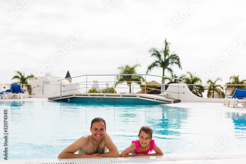 Father playing with his daughter in swimming pool © Angelov