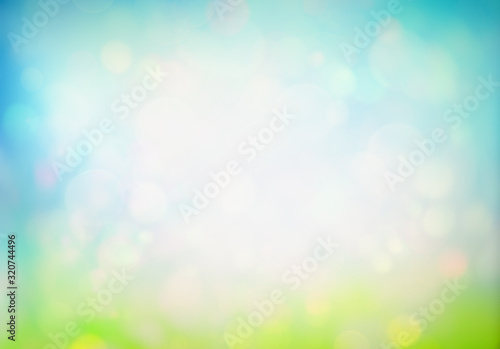 Spring or summer abstract nature background with fresh grass on blue sky back...