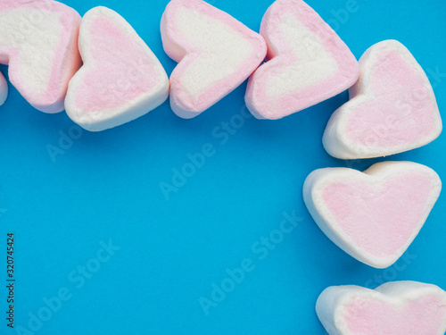 marshmallow snack in heart shape. Decorate design Love on trendy classic blue background. Heart symbol. Valentine's day concept.