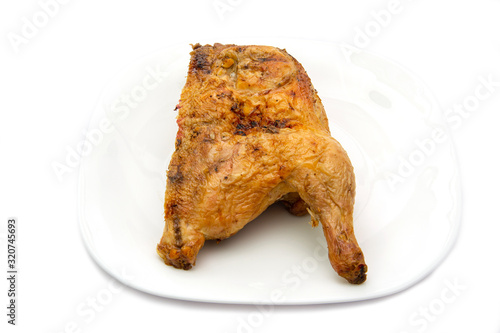 Tasty half grilled chicken on a plate isolated on white background photo