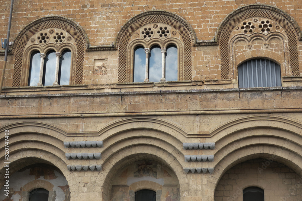 facade of yellow stone of an old church in Orvieto