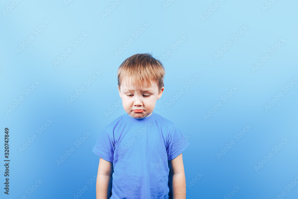Upset crying sad boy at blue background Stock Photo | Adobe Stock