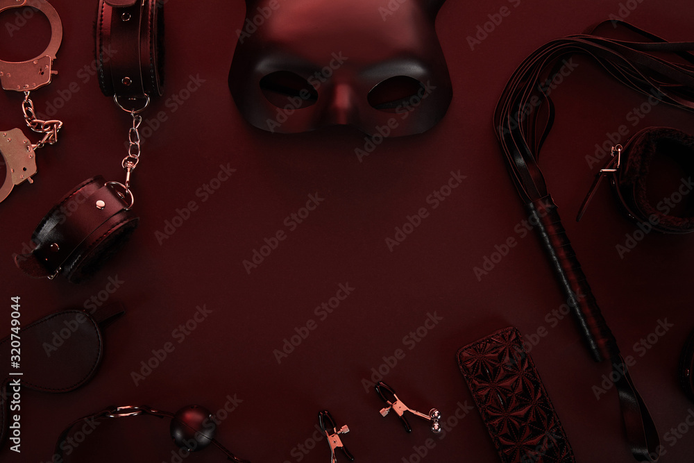 Obraz premium top view of sex toys in dark lighting on red background