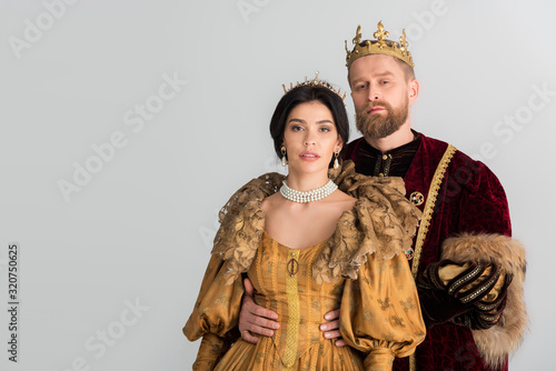 Fotografía king with crown hugging attractive queen isolated on grey