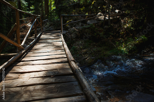 Wooden bridge with steps on the eco-trail along the rocks and mountain river in Bulgaria  Smolyan city. Equipped tourist road through the forest for sightseeing tours and walks