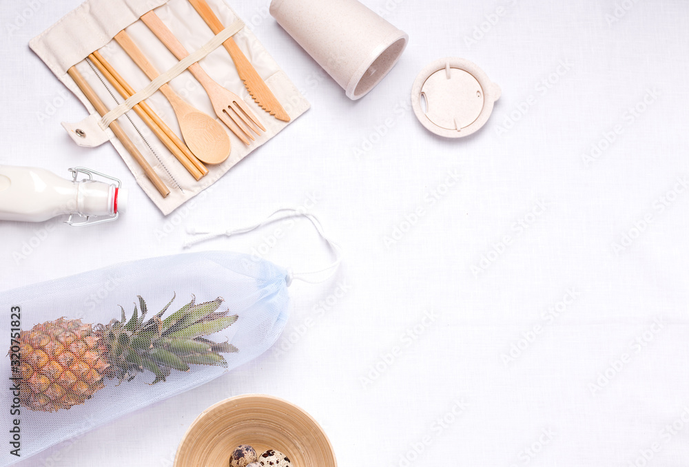 cutlery made of bamboo next to an eco bag on a linen background with copy space. zero waste concept and freedom from plastic cutlery made of bamboo next to an eco bag on a linen background with copy space. zero waste concept and freedom from plastic