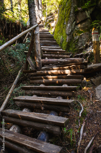 Wooden bridge with steps on the eco-trail along the rocks and mountain river in Bulgaria  Smolyan city. Equipped tourist road through the forest for sightseeing tours and walks