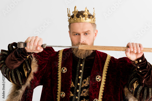 serious king with crown holding sword isolated on grey